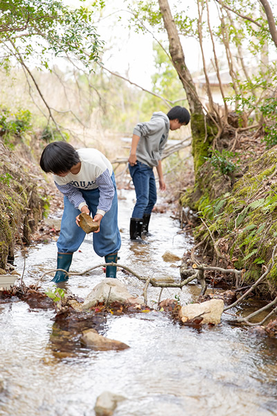 裏庭に流れる川で魚捕りをするご兄妹