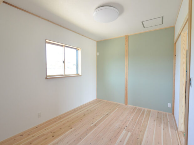 洋室の壁は一面アクセントカラーに。床は杉の無垢板